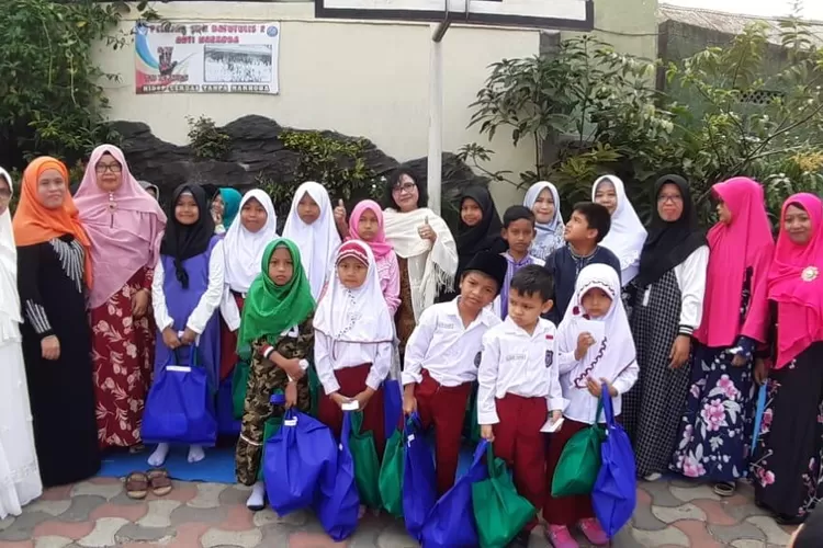 BERBAGI: Kepala SDN Batutulis 2, Ni Made Wilastri, beserta guru dan orang tua murid foto bersama dengan anak yatim piatu saat santunan, kemarin.