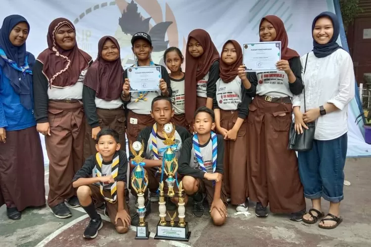BANGGA: Siswa SDN Batutulis 2 Kota Bogor terlihat bangga saat menunjukan piala yang berhasil diraih dalam ajang lomba Satya Jati Pratama Scouting Competition III 2019.