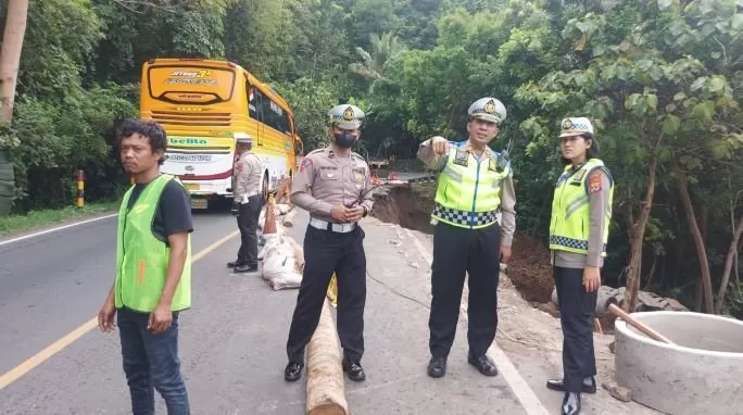   Kasi Audit dan Inspeksi Dirlantas Polda DIY, AKP Amir Machmud (tengah)  melakukan pengecekan di lokasi longsor (Sukro Riyadi) 