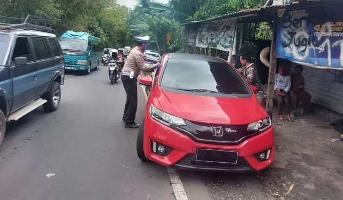 Personel Sat Lantas Polsek Piyungan Polres Bantul Polda DIY mengatur arus kendaraan dilokasi longsor (Sukro Riyadi)  