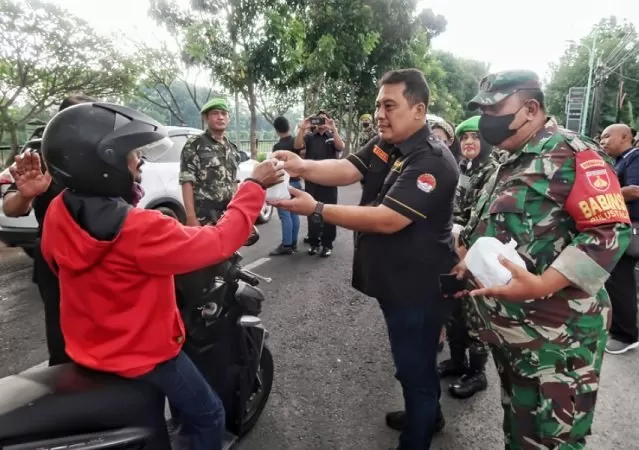 Ketua Umum Forum Komunikasi Organisasi Massa RI, Adhi Siswanto WN SPd STh (tengah) membagikan takjil kepada masyarakat Kota Semarang bersama TNI AD dan Resimen Yudha Putra.
