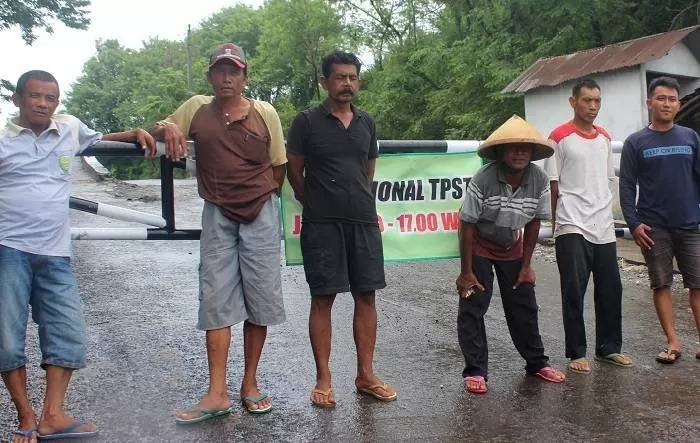 Warga berkumpul di pintu masuk menuju dermaga pembuangan sampah. (Foto: Sukro R)