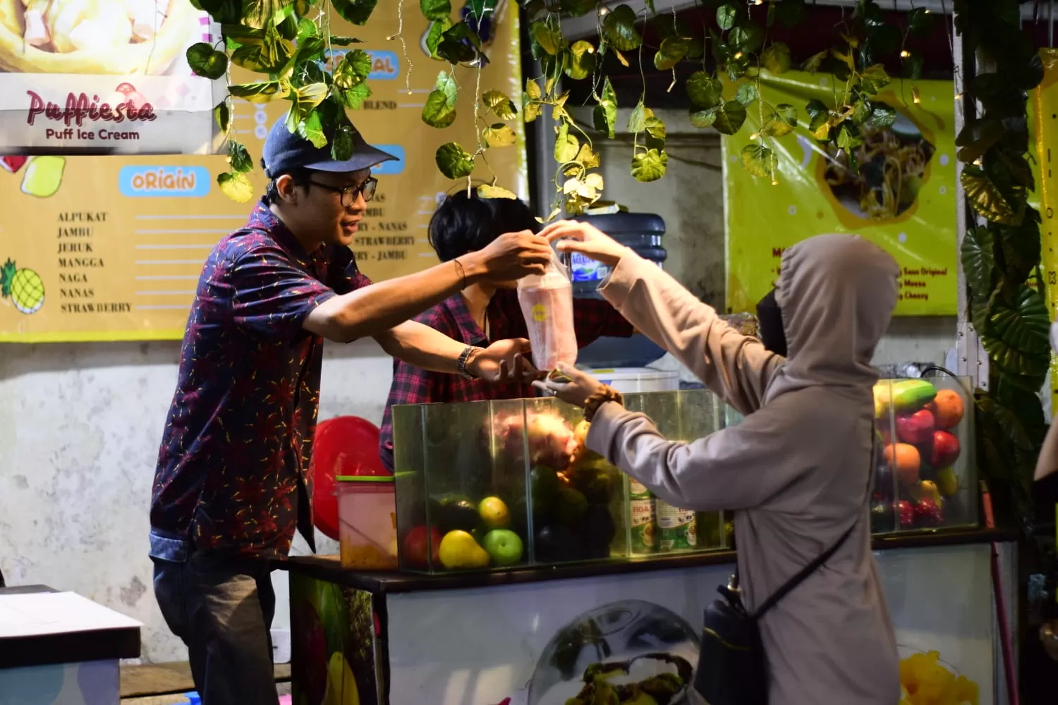 Arka (bertopi) pemilik Mimik Juice saat melayani pembeli.  (Latief NR)