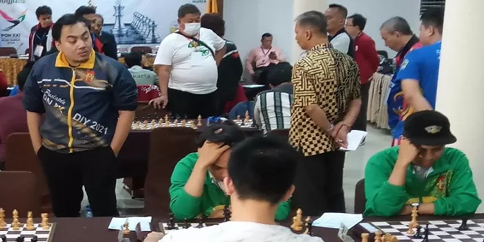 NM M Kahfi Maulana (berdiri kiri) menyaksikan rekan-rekannya di nomor beregu saat melawan Banten kemarin. Kahfi sukses meraih tiket PON XXI Aceh-Sumut 2024 usai meraih 3,5 poin dari 4 babak yang telah