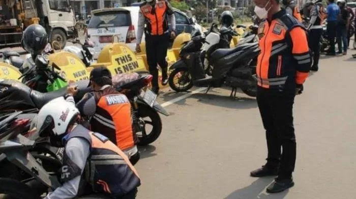 Petugas Sudinhub Jakarta Utara menertibkan motor di parkir liar yang mengganggu kelancaran lalu lintas. (Wilfrid)