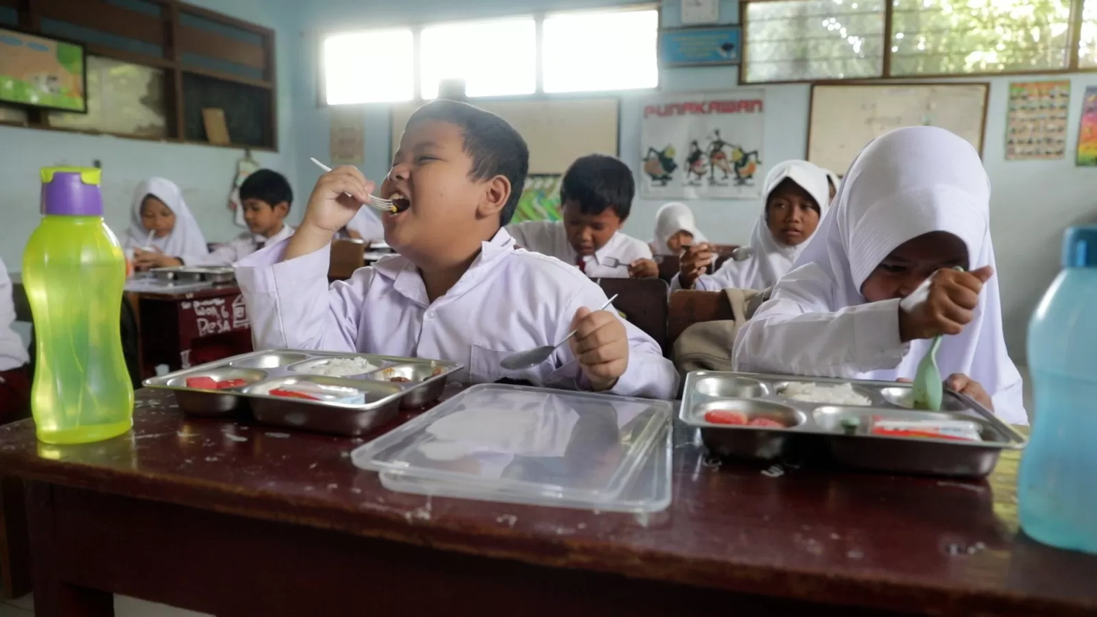 Murid-murid SDN 1 Donohudan, Boyolali, Jawa Tengah, menikmati makan bergizi gratis yang dilakukan secara serentak di 26 provinsi mulai Senin/6 Januari 2025.