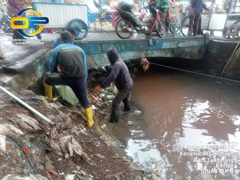 Petugas lapangan membersihkan saluran air untuk mencegah banjir Tangerang.( Foto: ppid.tangerangkota.go.id)