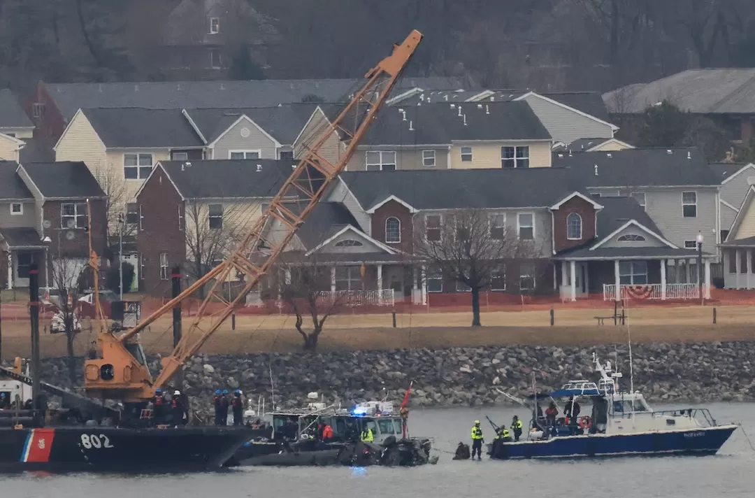 Sebuah kapal Penjaga Pantai AS dengan derek datang ke lokasi untuk mencoba dan mengambil sisa-sisa helikopter Black Hawk di dekat Bandara Nasional Ronald Reagan Washington. (Foto: reuters.com)