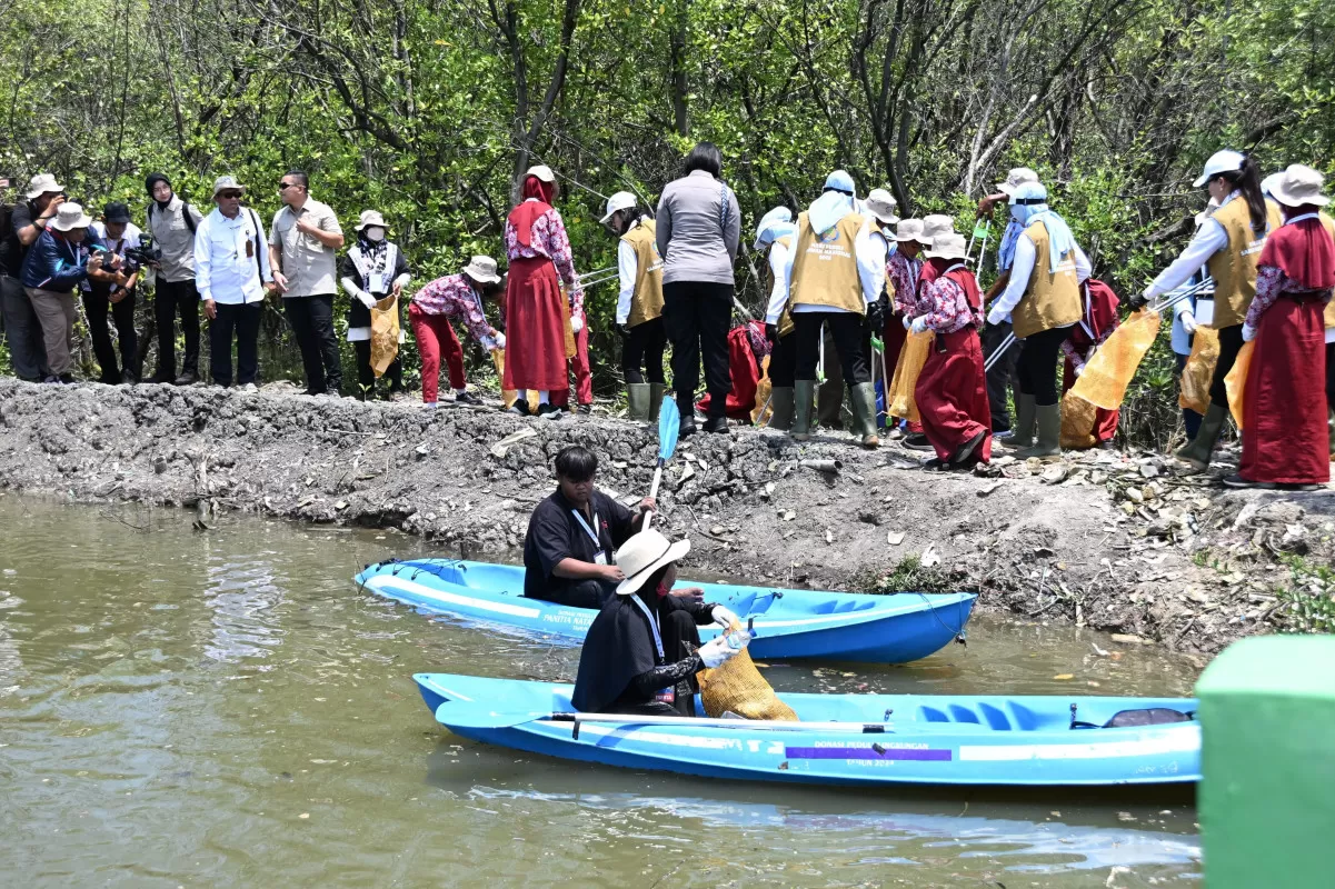 Para peserta Aksi Bersih Mangrove membersihkan kawasan pesisir untuk menjaga kelestarian ekosistem dan keseimbangan lingkungan.(Foto: dok. Kemensos)