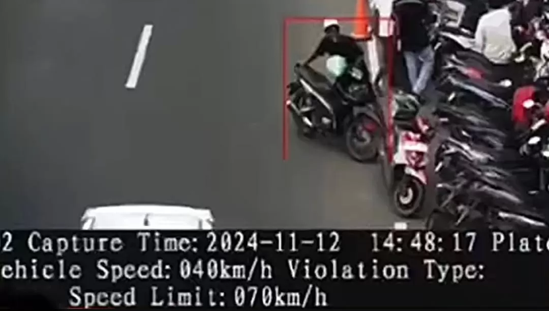 Tangkapan layar ETLE menunjukkan motor didorong tukang parkir di pinggir jalan raya. (Foto: Instagram @fakta.indo)