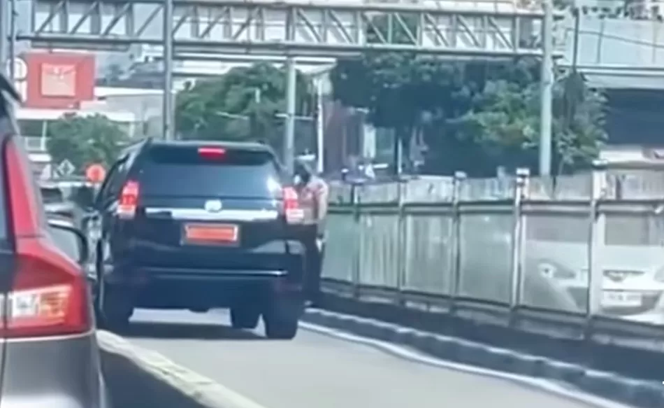 Mobil dinas pejabat melintas di jalur busway, disambut hormat dua polisi lalu lintas. (Foto: Instagram @fakta.indo)