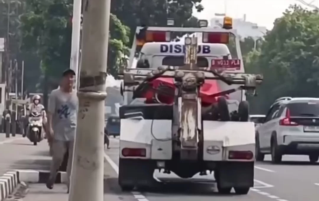 Petugas Dishub terekam menerima sebungkus rokok dari sopir bajaj di kawasan Salemba. (Foto: Instagram @fakta.indo)