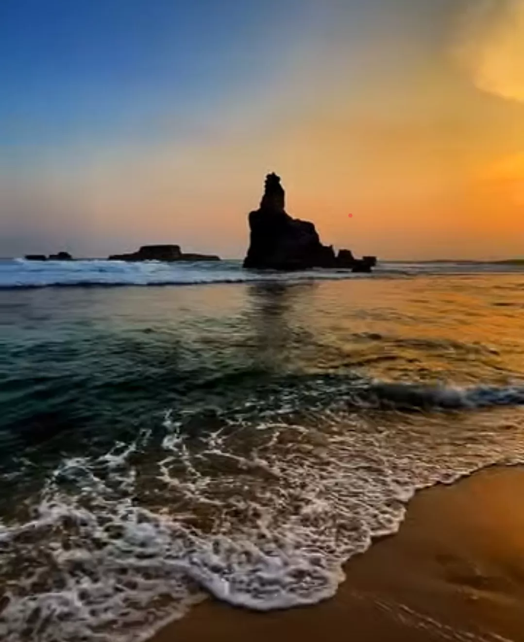 Mentari tenggelam di Pantai Buyutan, memancarkan cahaya keemasan di atas ombak dan batu karang. (Foto: Instagram @buyutanbeach_official)