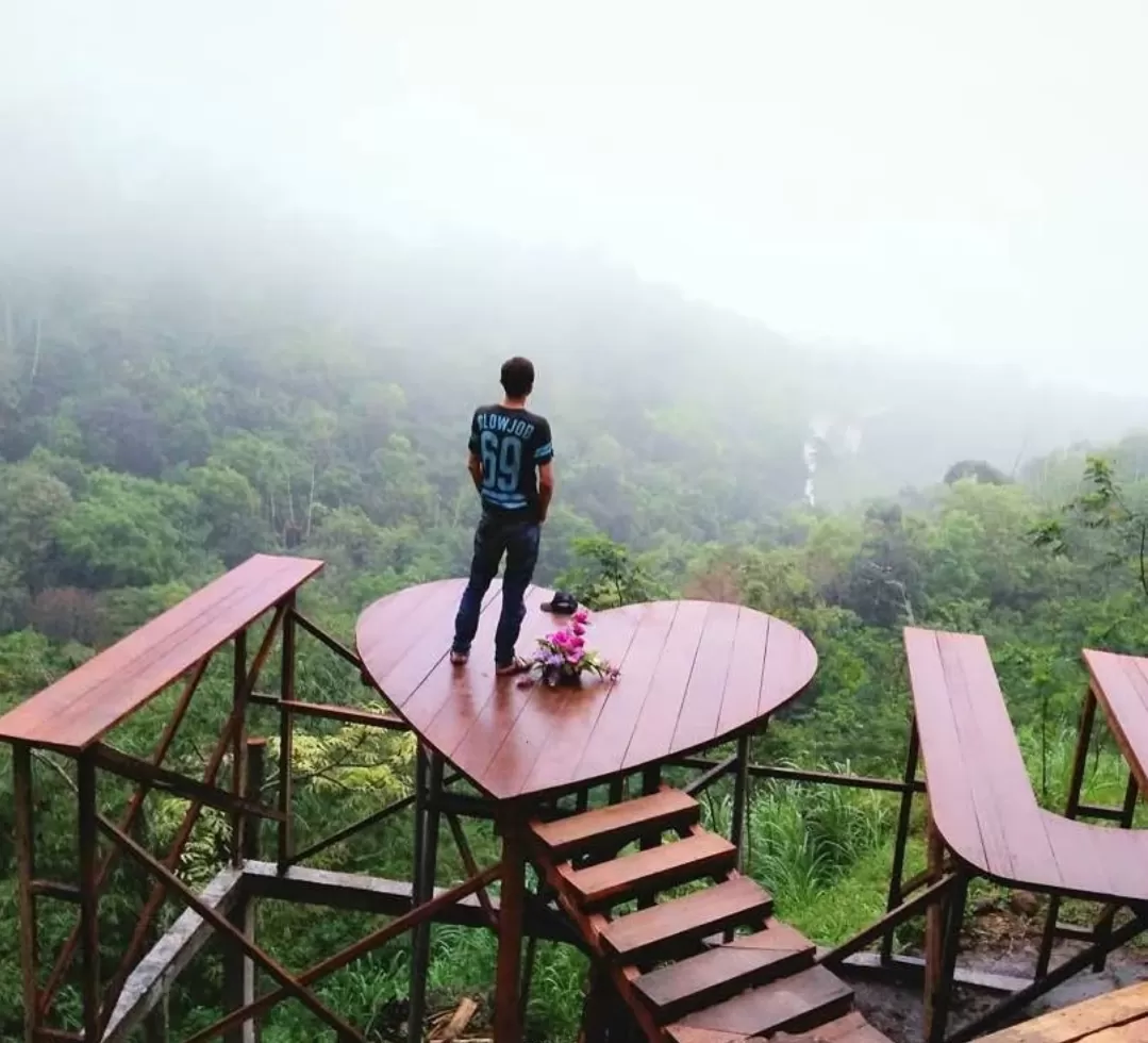 Pengunjung berfoto di Lembah Cinta Claket Adventure Park dengan latar lembah hijau yang memukau. (Foto: Instagram @claketadventurepark)