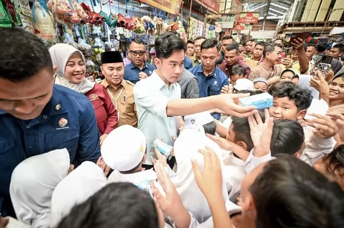 Potret Wapres RI, Gibran Rakabuming Raka saat membagikan sekotak susu untuk para siswa di Pasar Tradisional Palangka Raya, Kalimantan Tengah. (Instagram.com/@gibran_rakabuming)