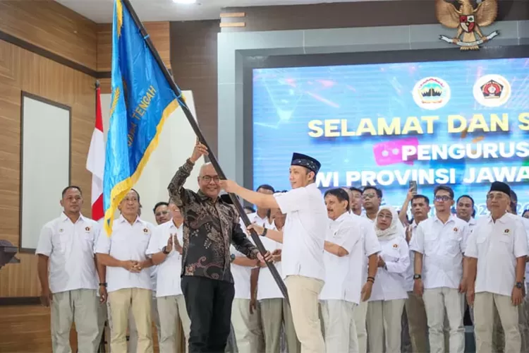 Ketua PWI Pusat, Akhmad Munir menyerahkan pataka kepada Ketua PWI Jawa Tengah, Setiawan Hendra Kelana dalam pelantikan di Wisma Perdamaian, Selasa 2 Desember 2025. 