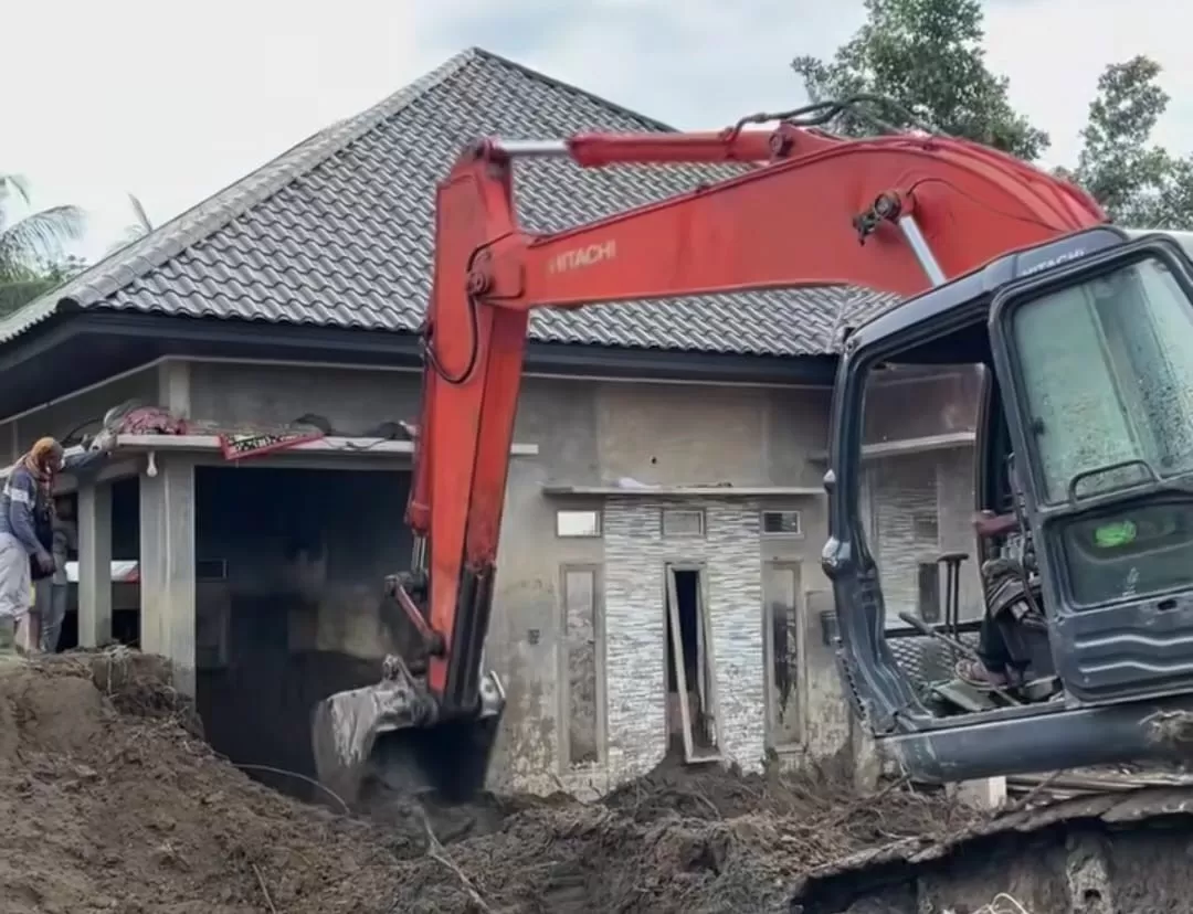 Momen warga di Aceh mulai membersihkan lumpur di rumahnya pascabanjir dengan alat berat. (Instagram/syahrur_sr647)