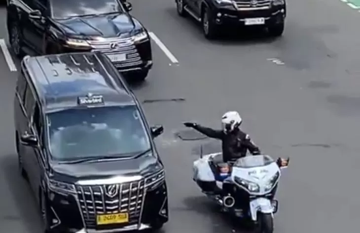 Tampak oknum polisi pengendara motor patwal kendaraan dinas nomor plat mobil RI 36 yang menunjuk-nunjuk sopir taksi Toyota Alphard.  (X.com @rieribet)