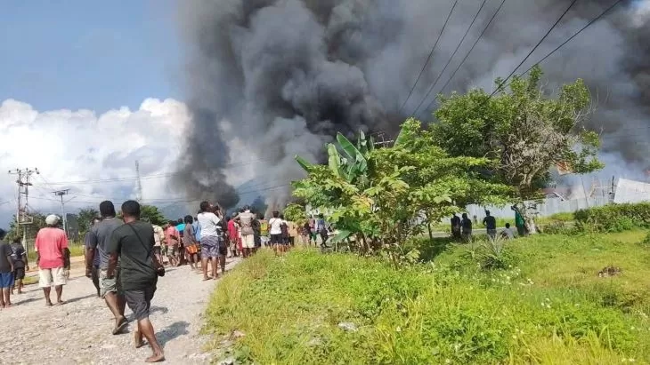 Asap hitam membumbung dari bangunan yang dibakar saat kerusuhan SARA di Kabupaten Yalimo, Papua Pegunungan. Enam anggota Kopassus dievakuasi pasukan Brimob dan TNI. (Puspen TNI)