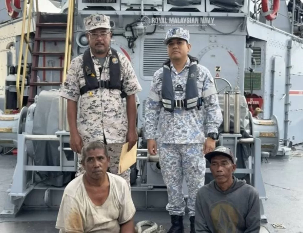 AL Malaysia menyelamatkan dua nelayan WNI (duduk) dekat Pulau Jarak. (AL Malaysia)