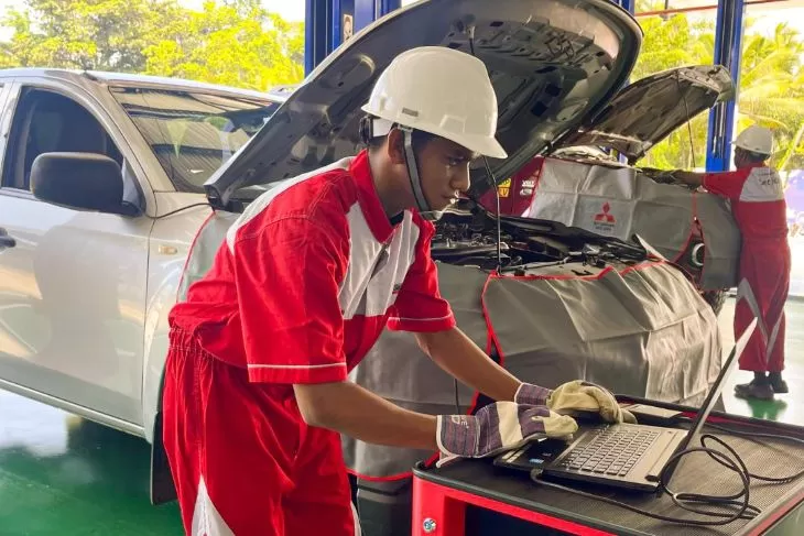 Teknisi bengkel Mitsubishi tengah melakukan pemeriksaan terhadap bagian mobil yang akan menjalani perjalanan jauh libur Nataru. (Foto: MMKI)
