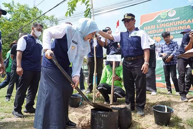 MENANAM POHON: Bupati Berau Sri Juniarsih didampingi Kepala DLHK Berau Mustakim saat melaku-kan penanaman pohon bersama dalam rangka memperingati Hari Lingkungan Hidup.