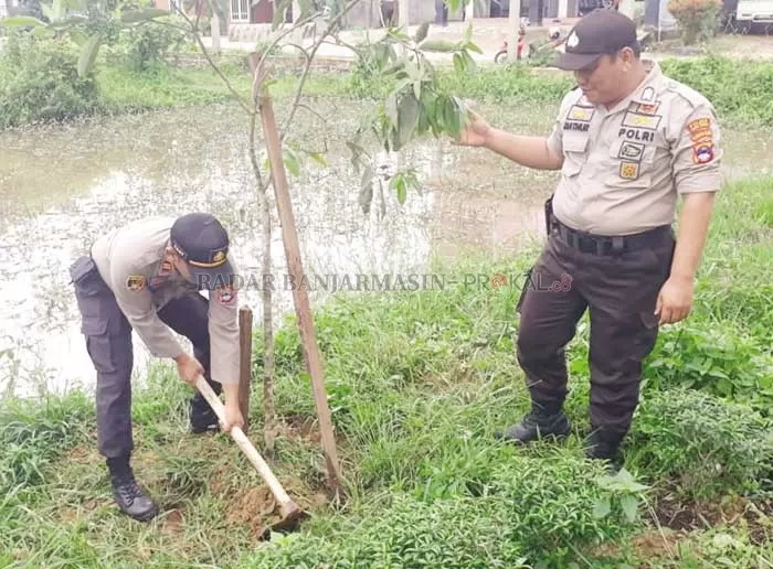TANAM POHON: Kapolsek Angsana Iptu H Tony Haryono melakukan penanaman bibit pohon mangga di wilayah Kecamatan Angsana.