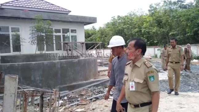 KUNJUNGAN LOKASI: Asisten Perekonomian dan Pembangunan Setda Tanah Bumbu, Suhartoyo berkunjung ke lokasi pembangunan Puskesmas Rawat Inap Sebamban II Desa Karang Indah Kecamatan Angsana untuk melihat progres pembangunan puskesmas plus tersebut. (Foto Karyono/Radar Banjarmasin).