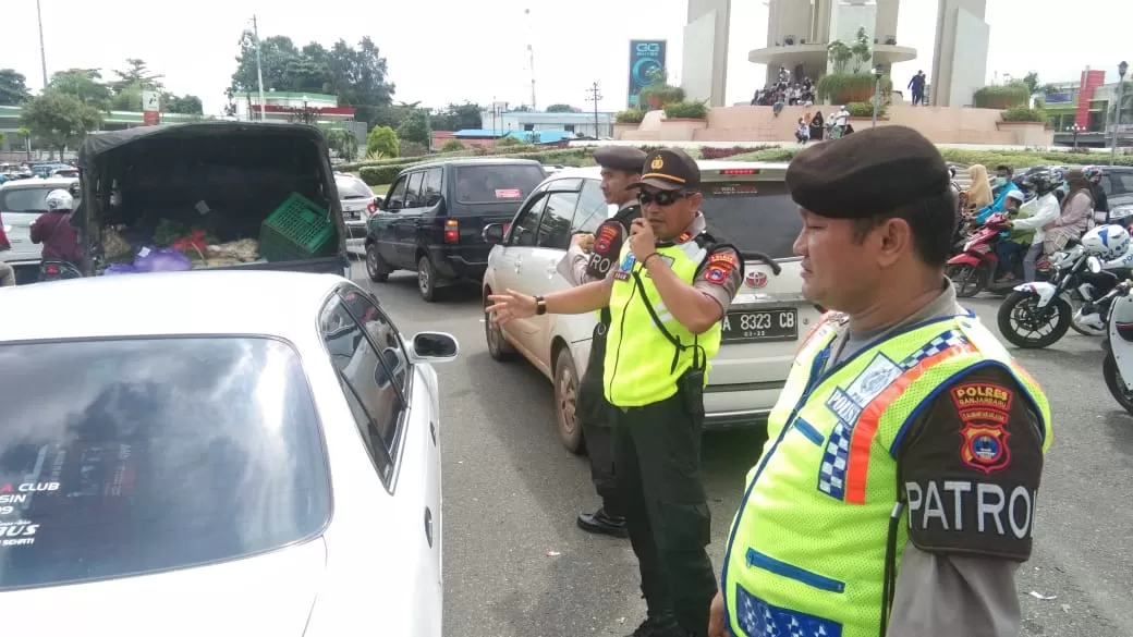 Perwira Pengendali Lalu Lintas, Iptu Khamdari SE (tengah) bersama para petugas lainnya saat mengatur kepadatan lalu lintas di Bundaran Simpang Empat Banjarbaru, Minggu (1/3). | FOTO: SUTRISNO/RADAR BANJARMASIN