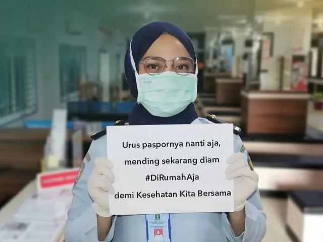 Pegawai di Kanim Kelas I TPI Banjarmasin menunjukkan tulisan agar masyarakat untuk sementara tak mengurus paspor.