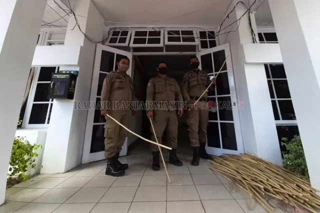 BERSENJATA ROTAN: Personel Satpol PP Banjarmasin bersama setumpuk pukulan rotan di depan mako di Jalan KS Tubun, kemarin. Satpol PP menegaskan perlunya efek jera kepada pelanggar aturan PSBB. | FOTO: WAHYU RAMADHAN/RADAR BANJARMASIN