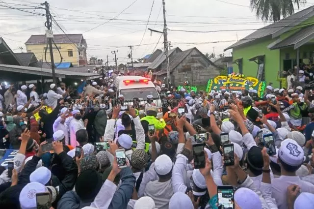 BERDUKA: Para jemaah menyambut ambulans yang membawa jenazah KH Ahmad Zuhdiannor di Belakang Masjid Jami Banjarmasin, Sabtu (2/5) sore. | FOTO: M OSCAR FRABY/RADAR BANJARMASIN