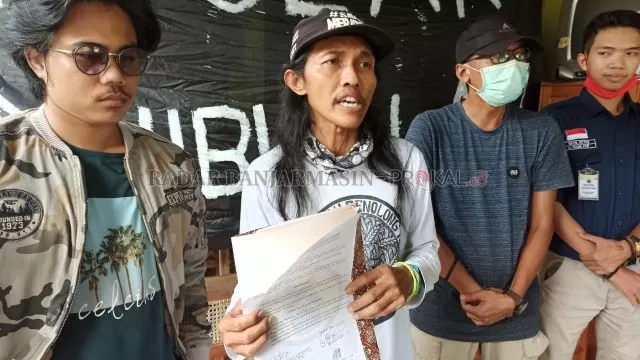 SIKAP: Direktur Eksekutif Walhi Kalsel Kisworo Dwi Cahyono menunjukkan surat terkait sikap mereka dalam penolakan RUU Omnibus Law Cipta Kerja, kemarin. | FOTO: SUTRISNO/RADAR BANJARMASIN