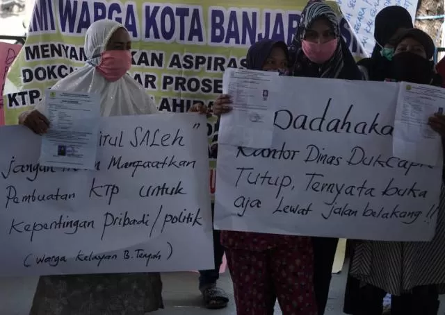 PROTES: Puluhan warga menggeruduk kantor Disdukcapil di Jalan Sultan Adam, kemarin. Mereka kesal karena pembuatan KTP yang berlarut-larut. | FOTO: WAHYU RAMADHAN/RADAR BANJARMASIN