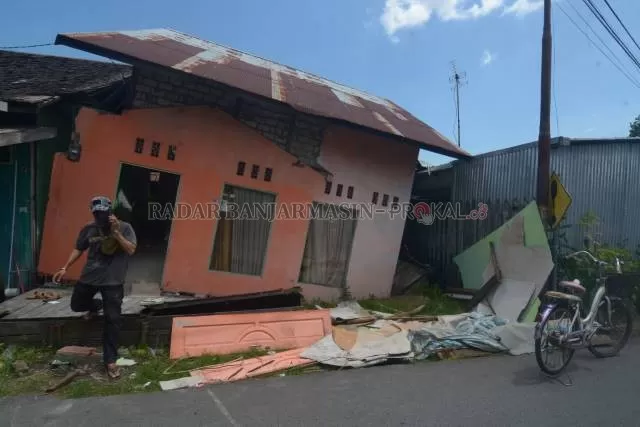 MIRING: Rumah yang dihuni Fi’i amblas, kemarin siang. Keluarganya mengungsi ke rumah kerabat terdekat. | FOTO: WAHYU RAMADHAN/RADAR BANJARMASIN