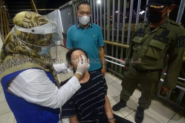 TES ACAK: Plh Sekdako Banjarmasin, Mukhyar (kaus biru) mengawasi tes antigen untuk pelanggar jam malam di Siring Balai Kota, akhir pekan tadi. | FOTO: WAHYU RAMADHAN/RADAR BANJARMASIN