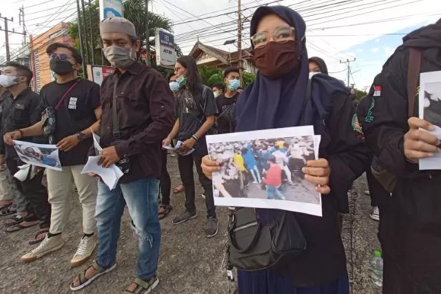 SOLIDARITAS: Mahasiswa menunjukkan foto-foto pemukulan mahasiswa kepada pengendara yang melintas di depan kampus UIN. | FOTO: BEM UIN ANTASARI FOR RADAR BANJARMASIN