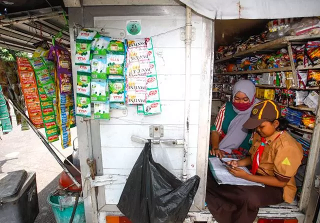 TARGET RAWAN: Seorang siswa sekolah belajar dengan ibunya di masa pandemi. | Foto: IST/JPG