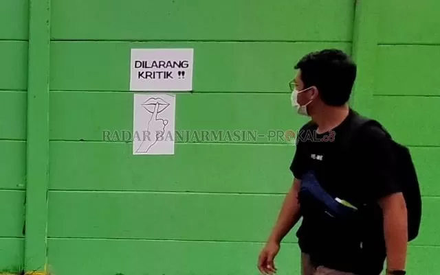 SSSTTT!: Setelah ditimpa cat warna hijau, pada tembok di Jalan RE Martadinata itu kini ditempeli pamflet sindiran. Entah oleh siapa. | FOTO: ENDANG SYARIFUDDIN/RADAR BANJARMASIN