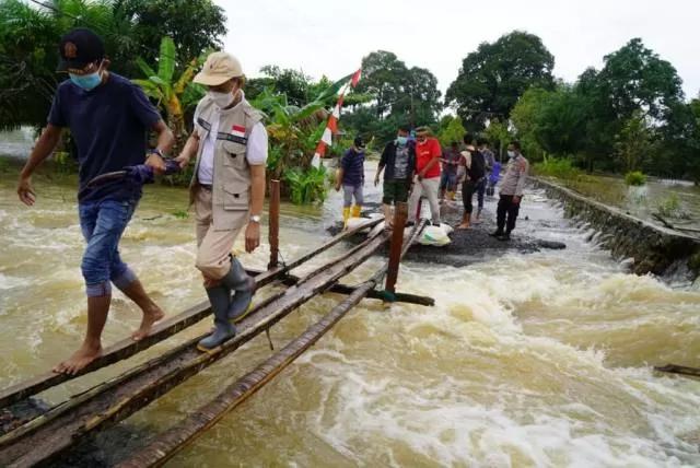 GERAK CEPAT: Sekda Pemkab Tanbu Ambo Sakka meninjau banjir di Lasung yang kembali meluap akibat intensitas curah hujan tinggi.