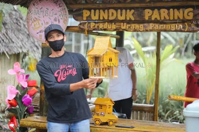INSPIRATIF: Syahridin memperlihatkan salah satu kerajinan lokal yang dijual di pasar budaya di desanya. | FOTO: WAHYUDI RADAR BANJARMASIN