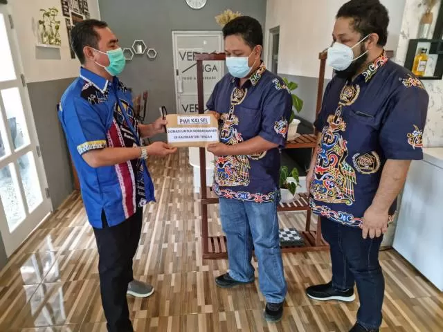 PEDULI: Ketua PWI Kalsel, Zainal Helmie menyerahkan bantuan pada Sekretaris PWI Kalteng, Ika Lelunu.