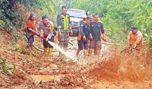 SIGAP: Petugas bersama warga saat berjibaku menangani longsor yang menutupi akses jalan warga.