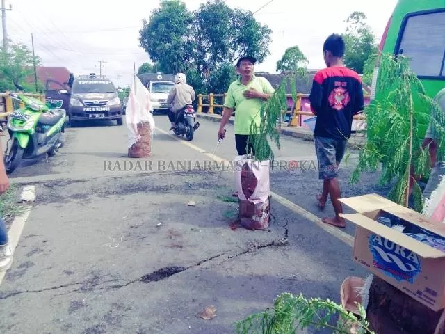 BAHAYA: Oprit Jembatan Pinang Habang mengalami penurunan 20 Cm. Bahkan, badan jalan juga retak memanjang. Angkutan berat lebih baik cari jalan alternatif. | Foto: Muhammad Akbar/Radar Banjarmasin