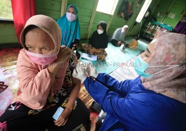 DI RUMAH LANSIA: Petugas vaksinator menyuntikkan vaksin pfizer kepada lansia di rumahnya di perbatasan Banjarbaru-Tanah Laut atau tepatnya di kelurahan Bangkal Cempaka Banjarbaru. | Foto: Muhammad Rifani/Radar Banjarmasin