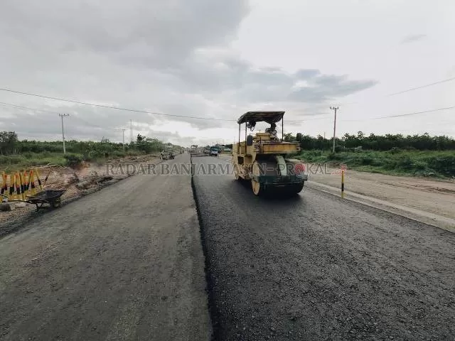 MULAI BAGUS: Pekerja mengaspal Jalan Gubernur Syarkawi, kemarin. Pertengahan tahun tadi, ruas jalan ini tak bisa ditembus karena rusak parah. | FOTO: M OSCAR FRABY/RADAR BANJARMASIN