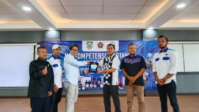 PENGHARGAAN : Ketua PWI Kalsel, Zaenal Helmie (tiga dari kanan) saat memberikan piagam penghargaan kepada Bupati Balangan yang diwakili Kadiskominfosan setempat. : FOTO MC FOR RADAR BANJARMASIN