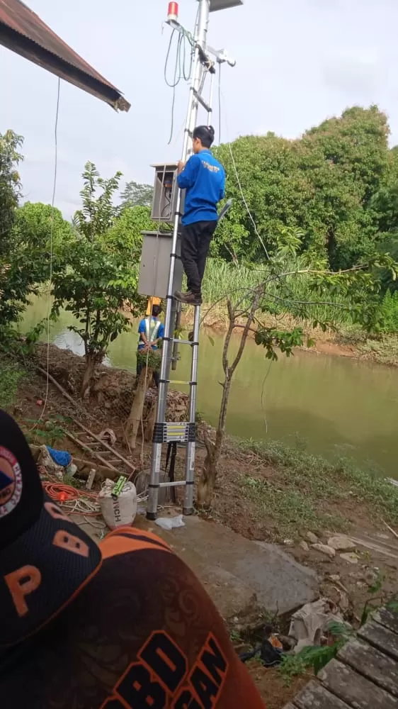 PENCEGAHAN : Petugas BPBD Balangan saat memasang alarm pendeteksi banjir di Kecamatan Juai. : FOTO MC FOR RADAR BANJARMASIN.