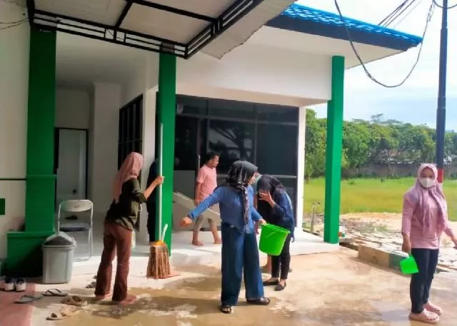 GOTONG ROYONG:  Pegawai Radio Swara Bersujud milik pemerintah daerah gotong royong di halaman kantor baru.