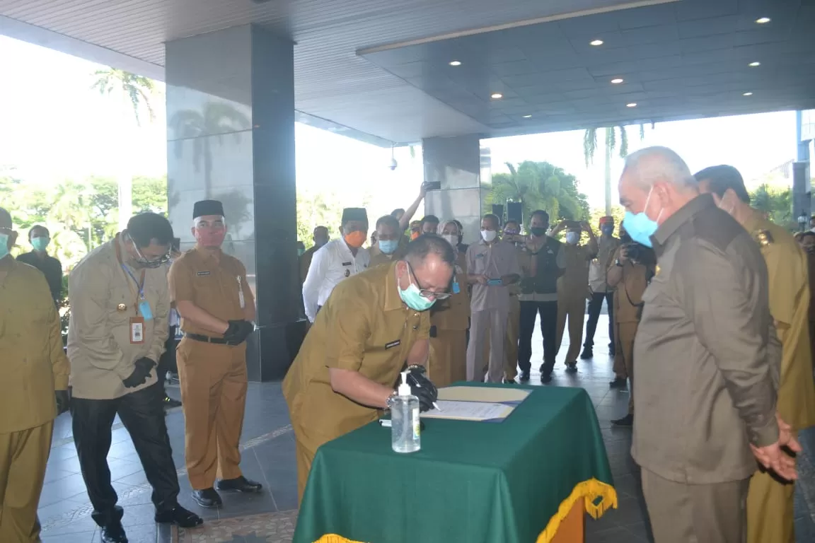 SERAH TERIMA : Pj Sekda Mahulu Stephanus Madang menandatangani berita acara penerimaan Bantuan Cadangan Pangan Pemerintah (CPP) Provinsi Kaltim kepada korban dampak pasca banjir di Kota Samarinda dan pandemi Covid-19 di Kaltim, di Halaman Kantor Gubernur Kaltim, Selasa (23/6).